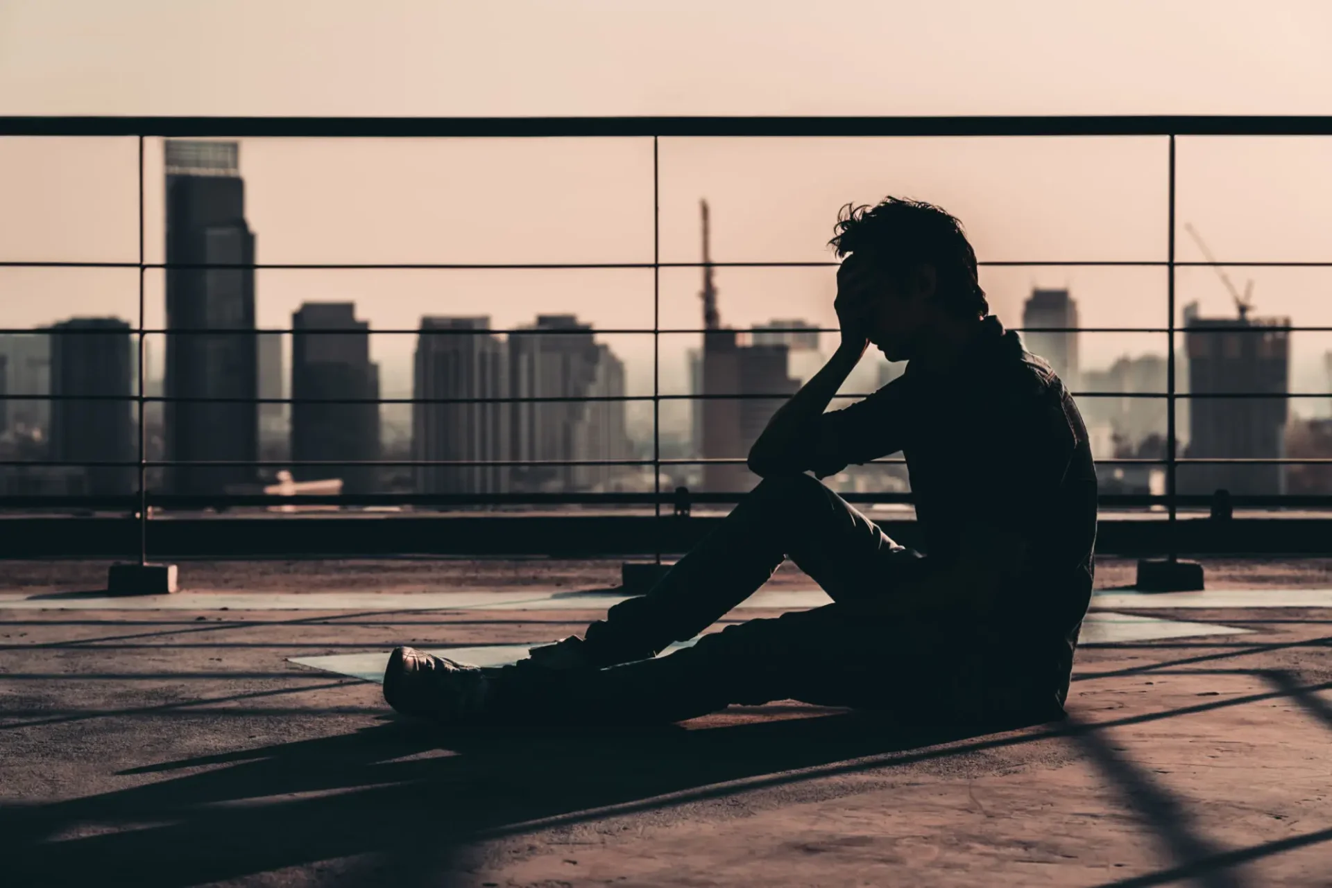 Silhouette of a man on the floor of a rooftop.